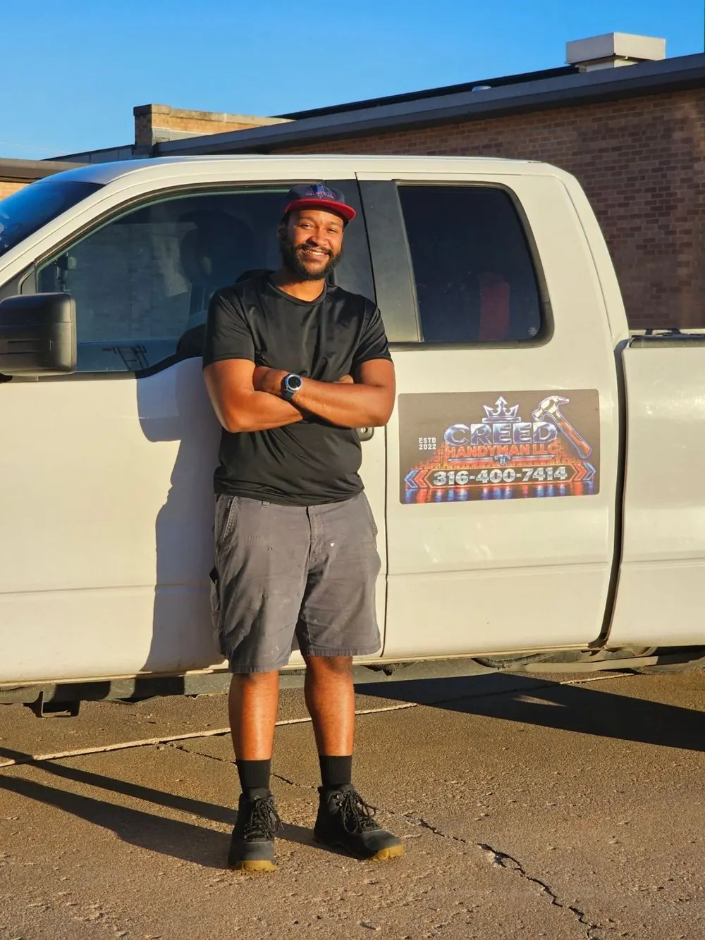 Bernard Reed, owner of Creed Handyman, standing by his work truck in Wichita